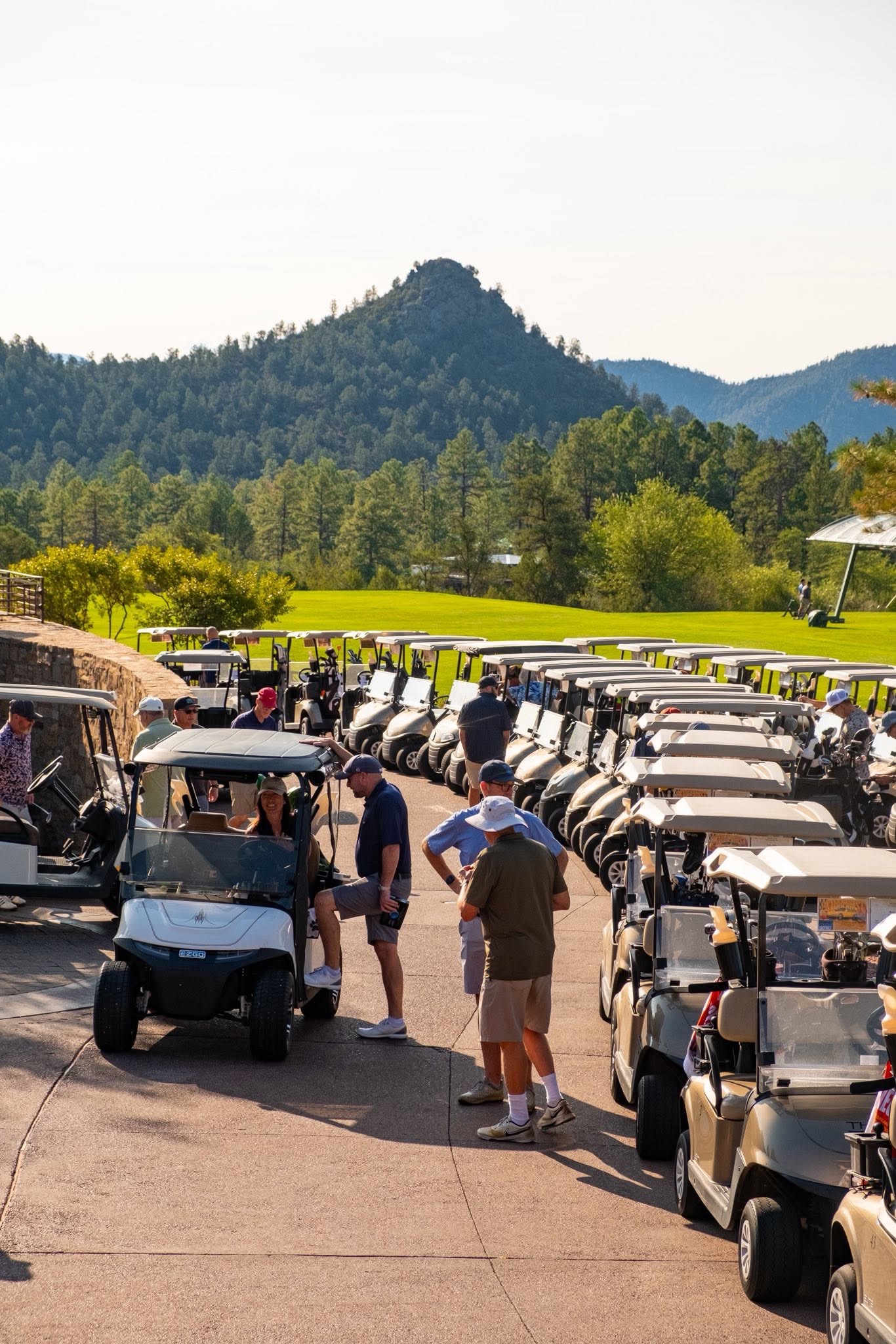 Golfers gathering with their carts before the tournament