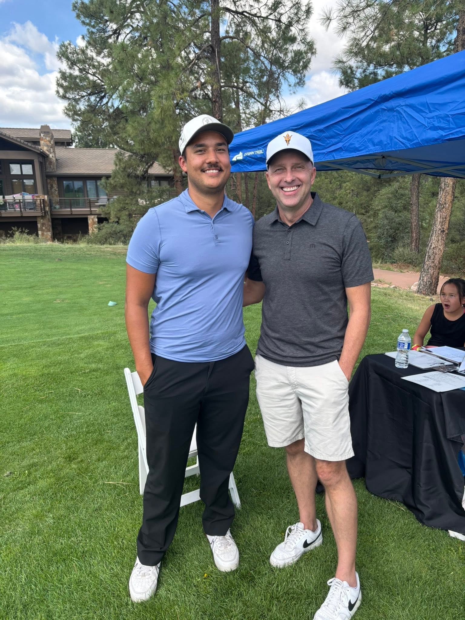 Two tournament participants smiling together beside the course