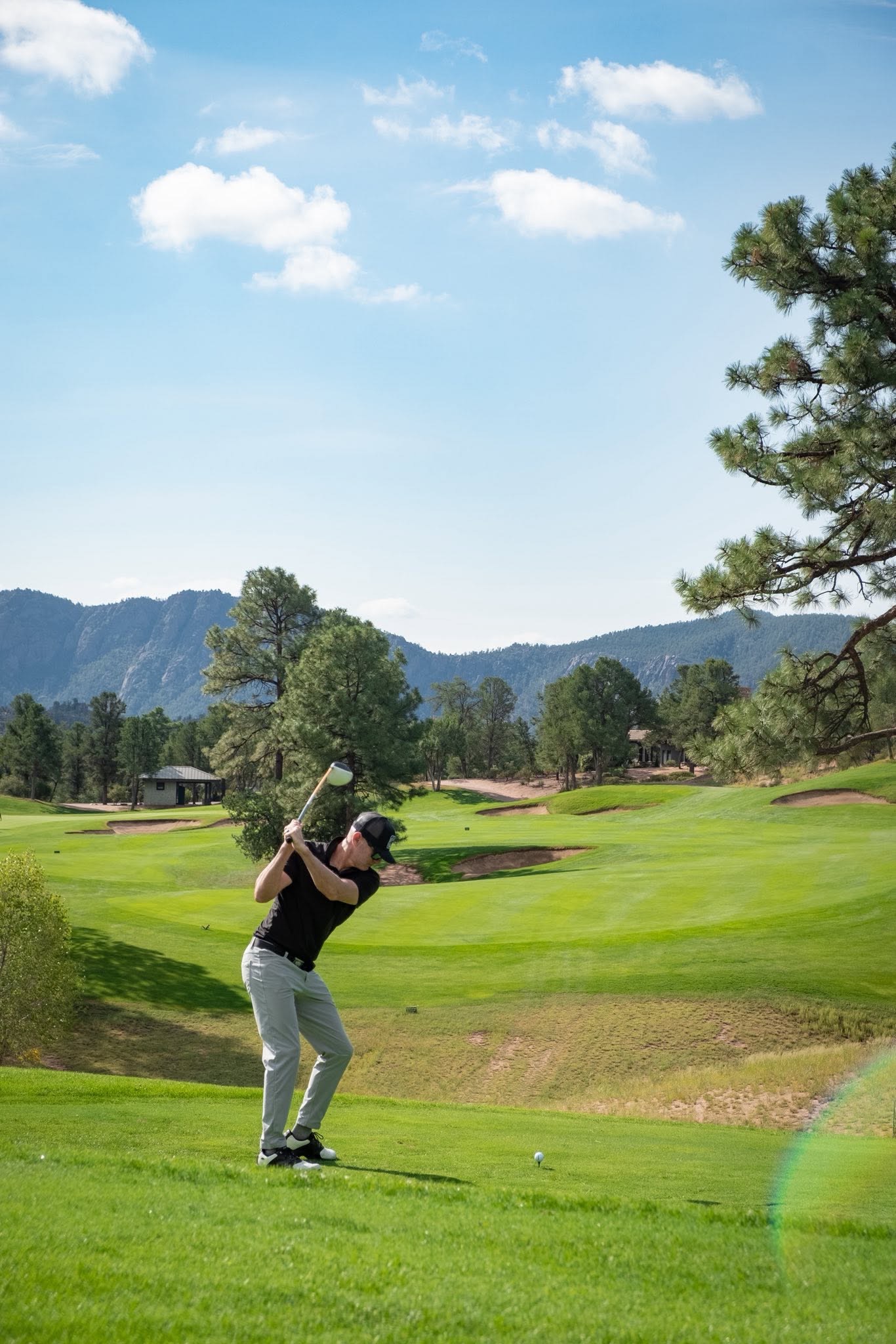 A golfer teeing off on the mountain course