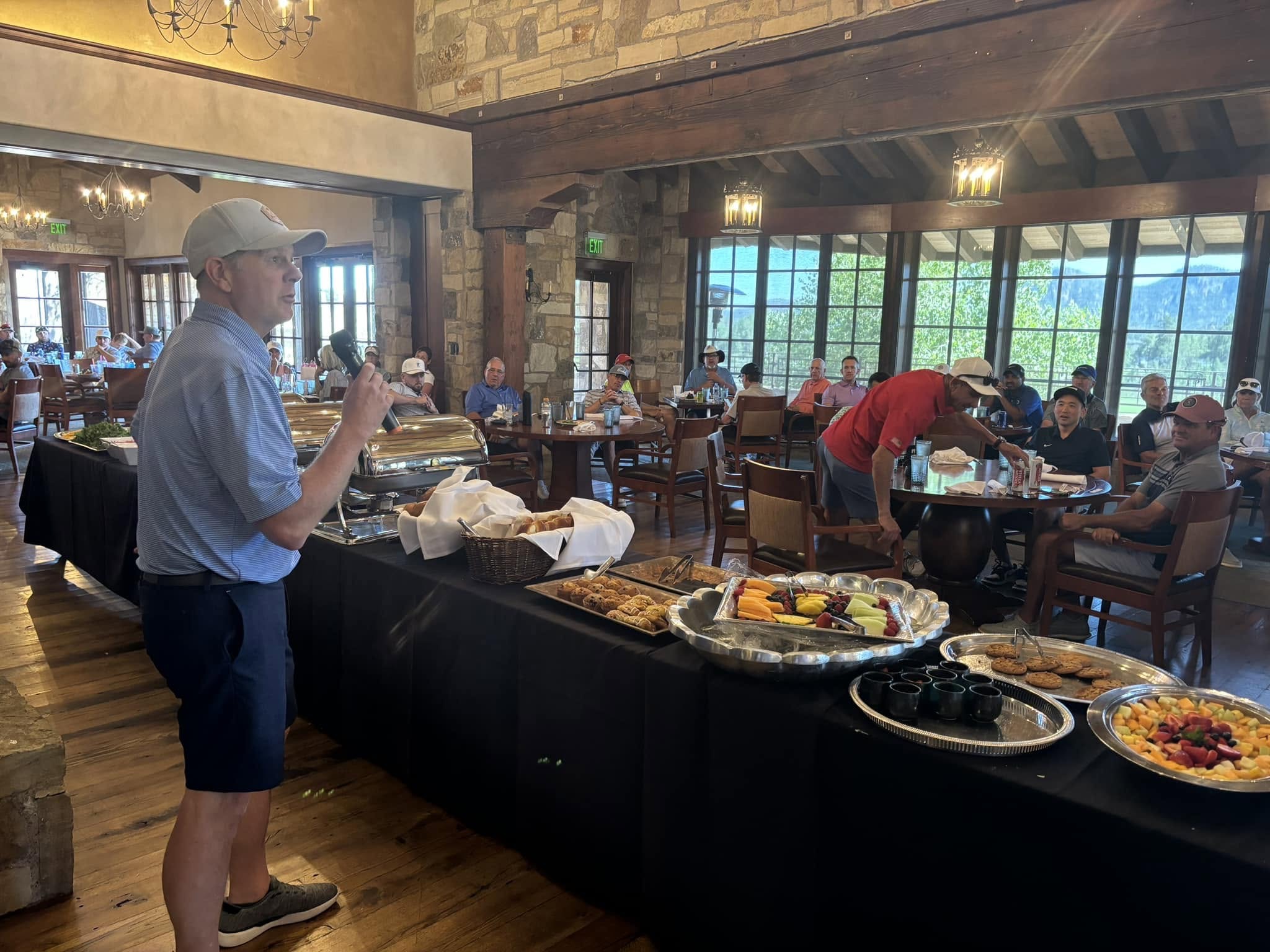 A tournament organizer speaking to golfers during the clubhouse luncheon