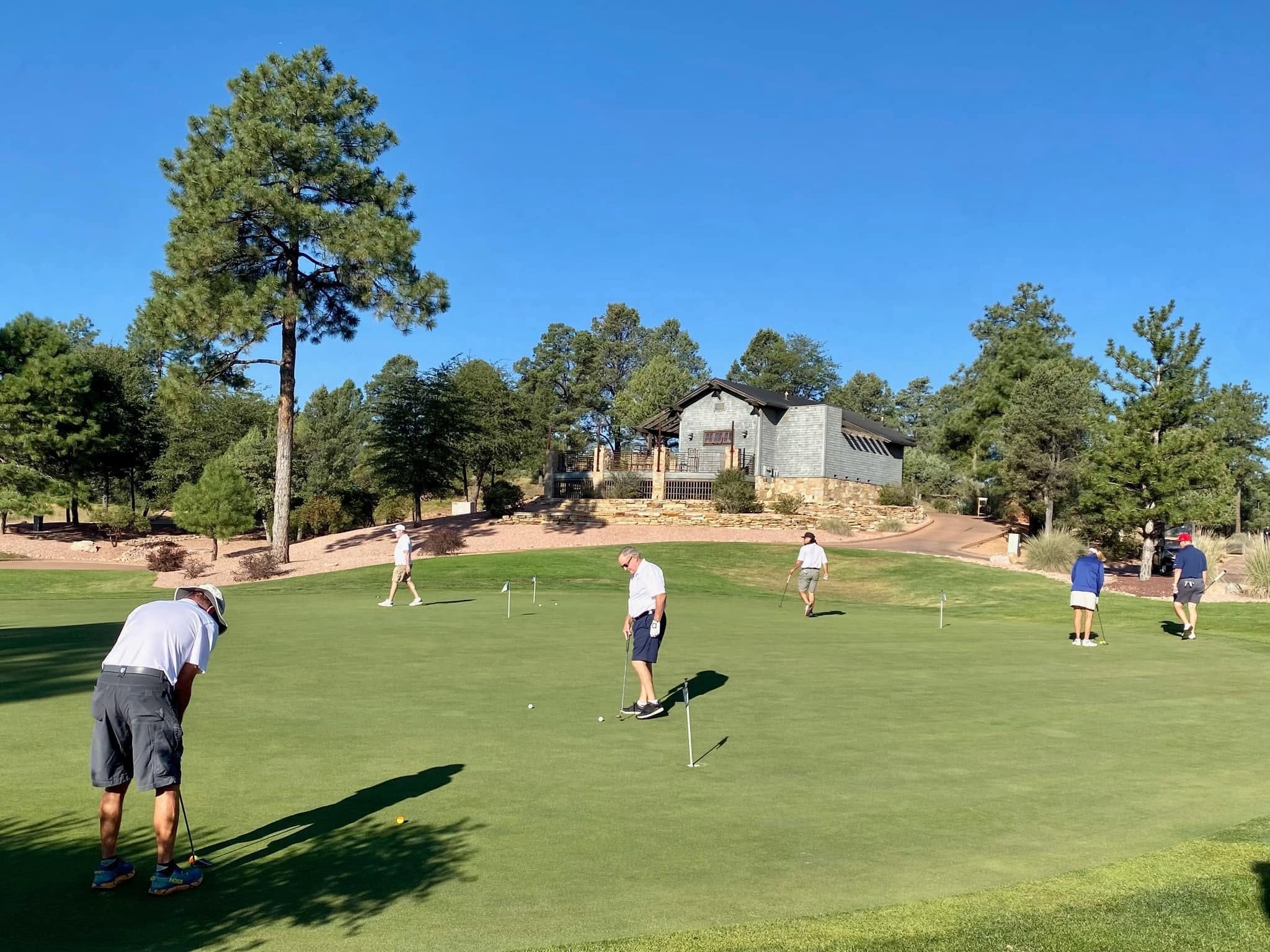 Golfers warming up together on the putting green before the tournament