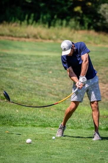 A tournament golfer striking a tee shot on the course